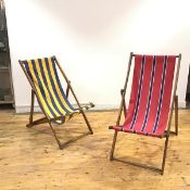 Two similar Edwardian wooden framed deckchairs, each with adjustable folding frame and striped sling