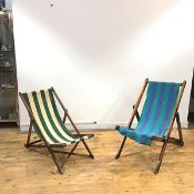 Two similar Edwardian wooden framed deckchairs, each with adjustable folding frame and striped sling