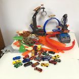 A collection of approximately twenty five Hotwheels cars, also tracks, starting gates, loops etc.