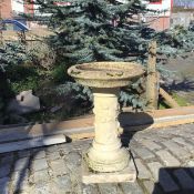 An ornate composition bird bath, the circular top with shallow bowl supported on a single column