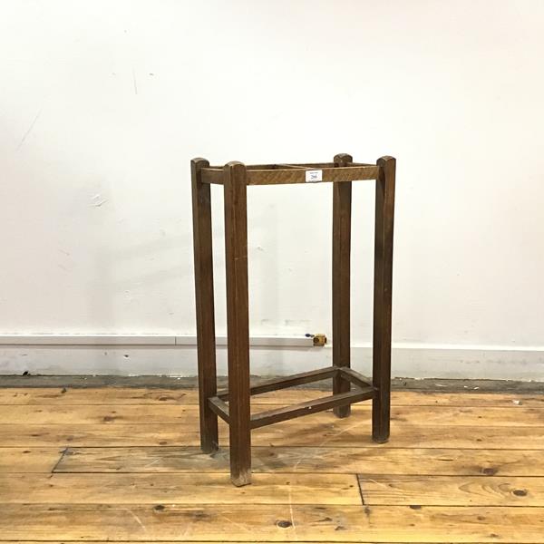 An early 20thc oak stick stand, the square section supports enclosing a two division rest, with