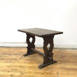 An oak trestle occasional table, the rectangular top on pierced baluster shaped supports united by