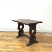 An oak trestle occasional table, the rectangular top on pierced baluster shaped supports united by