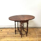 A reproduction wooden gateleg table, the oval top incorporating a pair of drop flaps, raised on