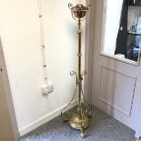 A Edwardian brass floor standing oil lamp, with copper burner, the stem with three ribboned supports