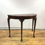 A 1930s semi eliptical table, in the Georgian style, the bow front top with moulded edge raised on