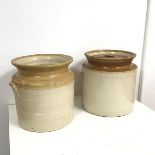 Two similar stoneware jars, one missing lid, the other with a collection of corks, one stamped