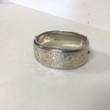 A 1960s Birmingham silver bangle with engraved foliate decoration to one half (h.2cm x 6.5 x 5.5) (
