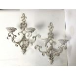 A pair of white painted iron wall sconces, each with two arms of interlocking C scroll design,