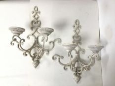 A pair of white painted iron wall sconces, each with two arms of interlocking C scroll design,