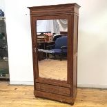 A late 19thc pitch pine wardrobe, probably French, the projecting cornice above a fluted frieze, the