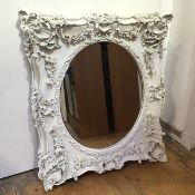 A modern rococo style mirror, the oval bevelled plate within elaborate composition frame, with