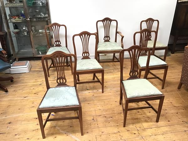 A set of seven Edwardian dining chairs in the George III style, each yoke shaped top rail above a