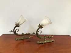 A pair of reproduction brass wall sconces in the Neoclassical taste with foliate plate and scroll