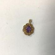 A 9ct gold pendant with a central faceted oval cut amethyst in claw setting with surround of C