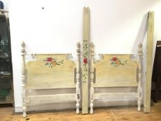 A modern turned wood single bed, the head and footboard painted with bouquets of flowers, raised