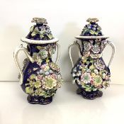 A pair of 19th century floral-encrusted pot pourri vases and covers, in the manner of Coalport, each