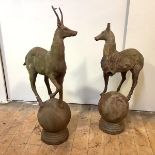 A pair of cast-iron pier finials, each modelled with a stag, one hoof raised, and mounted on a