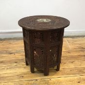 An early 20th century Indian carved hardwood tray table, the circular top with bone-inlaid depiction