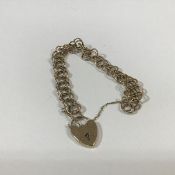 A 9ct gold chainlink bracelet, of fancy double hoop links, suspending a heart padlock clasp, with