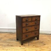 A Regency mahogany and ebony-lined miniature chest of two short and three long graduated drawers, on