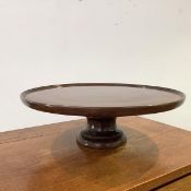 An Edwardian mahogany Lazy Susan, the dished circular top with moulded edge, on a turned base.