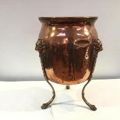 A copper jardiniere, c.1900, of urn form, the scroll-cast legs with lion mask surmounts and