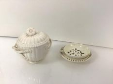 A 19th century creamware tea strainer on stand, the circular strainer with loop handle, the stand