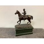 French School, a patinated metal bronze group of a horse and jockey, unsigned, mounted on a gilt-