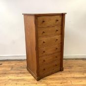 A late 19th century oak Wellington chest, of six graduated drawers, with locks to one side, on a