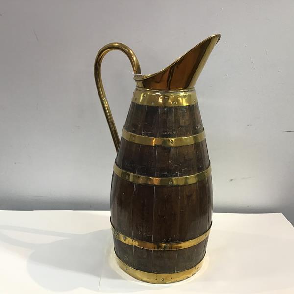 A large Edwardian brass-bound coopered oak pitcher, with elongated spout and three brass bands.