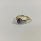 A ruby and diamond cluster ring, the oval-cut ruby claw-set within a band of ten round brilliant cut