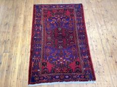 A hand-knotted Hamadan rug, the tomato red field with stylised interwoven flowers highlighted in