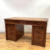 An Art Deco walnut pedestal desk, c. 1920/30, the rectangular top with tooled leather writing