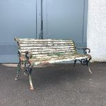 A Victorian cast-iron garden bench, the pierced ends incorporating foliate decoration enclosing a