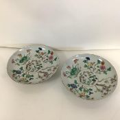 A pair of Chinese famille rose floral-decorated porcelain plates, each brightly painted in enamels