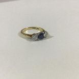 A three stone sapphire and diamond ring, the central square-cut sapphire flanked by a pair of