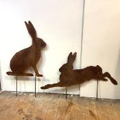 A large pair of metal lawn edging ornaments cut in profile and depicting one seated rabbit and one