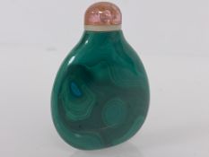 A Chinese carved malachite snuff bottle, of flattened oval form, with pink quartz stopper. 5.5cm