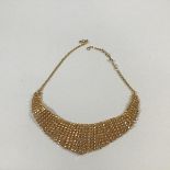 An Indian yellow metal fringe necklace, of graduated lines of discs, on a chain with hook clasp,