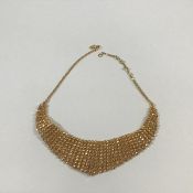 An Indian yellow metal fringe necklace, of graduated lines of discs, on a chain with hook clasp,