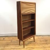 An unusual early 1960's bookcase of wedge shape, the tambour top enclosing pigeon holes above