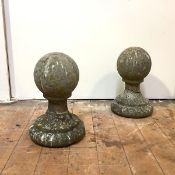 A pair of composition stone orb pier finials, mounted on socle bases. 38cm by 22cm diameter