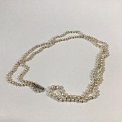 A long strand of graduated cultured pearls, on a silver clasp, largest pearl 6mm, length of strand