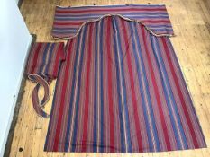 A large pair of inter-lined curtains in a striped fabric, in shades of blue, red and yellow, with