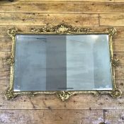 An Edwardian gilt-composition mirror in 18th century style, the rectangular bevelled plate within