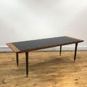 A 1960's occasional table, the teak frame with black plastic inset incorporating iridescent squares,