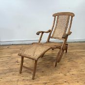 A late 19th century Campaign lounge chair, the arched top rail above a woven cane back, seat and