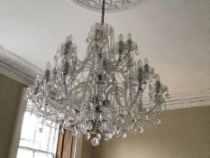 A large George III style cut and moulded glass twenty-four light chandelier, the scrolling candle