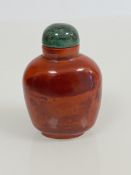 A Chinese red banded agate snuff bottle, with green hardstone stopper. 7cm